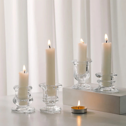 Bougeoir nordique en verre transparent posé sur une table décorée, avec une bougie allumée diffusant une lumière douce et romantique. Décoration  intérieure