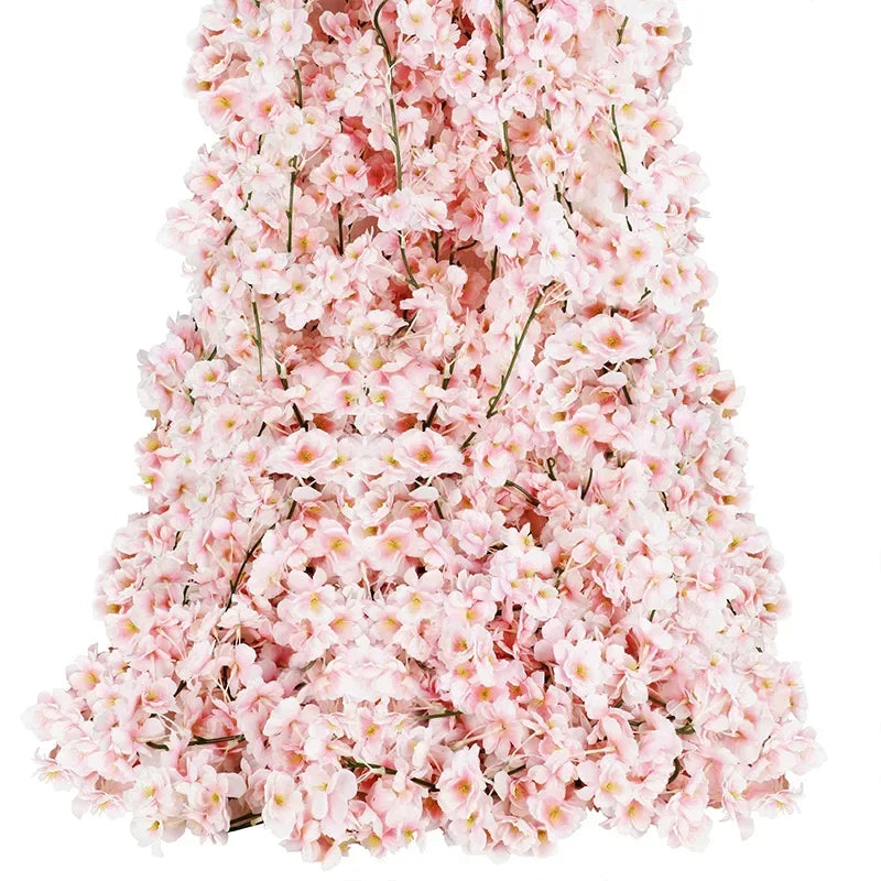 Guirlande de fleurs de cerisier artificielles roses suspendue sur un mur pour décoration romantique.