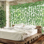 Guirlande de lierre artificiel vert suspendue sur un mur, décoration végétale réaliste en intérieur.