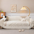 Housse de canapé en chenille beige posée sur un canapé moderne, utilisée comme jeté décoratif et couverture anti-poussière – style simple et élégant. Décoration  intérieure.