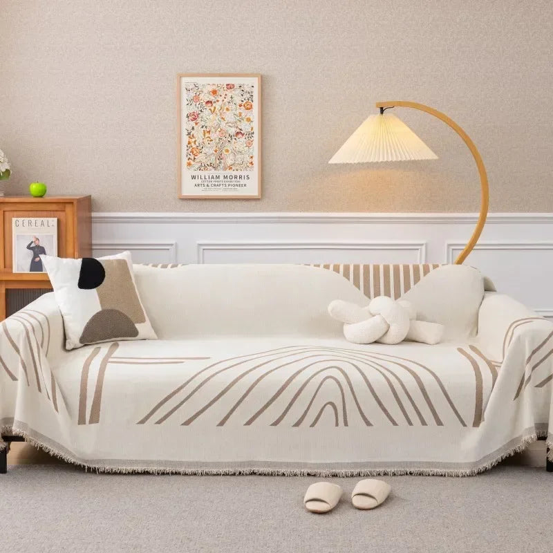 Housse de canapé en chenille beige posée sur un canapé moderne, utilisée comme jeté décoratif et couverture anti-poussière – style simple et élégant. Décoration  intérieure.