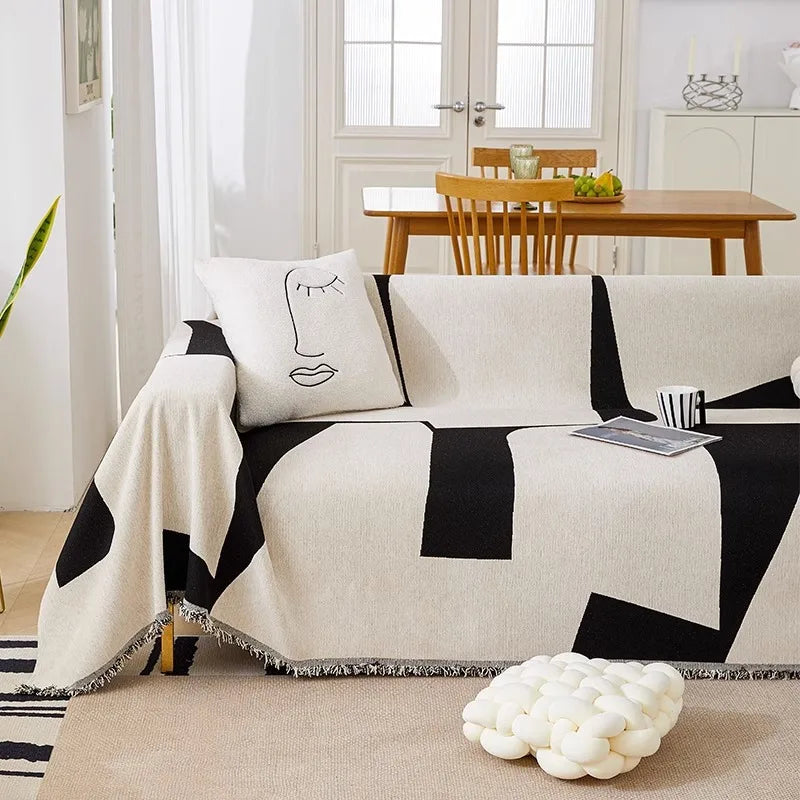 Housse de canapé en chenille à lignes noires, posée sur canapé droit dans un salon épuré et contemporain. Décoration intérieure