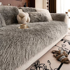 Housse de canapé en peluche douce couleur unie, installée sur canapé en L dans un salon moderne. Décoration intérieure