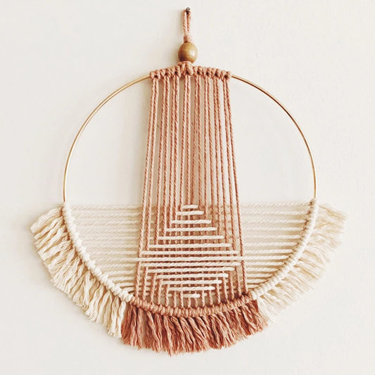 Macramé murale Rond  en macramé rose, noir et beige suspendue dans un salon bohème, tissage artisanal en coton naturel - Décoration intérieure