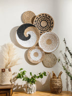 Panier mural en jonc de mer naturel tressé à la main, accroché sur un mur blanc dans un salon à la déco bohème. Décoration intérieure