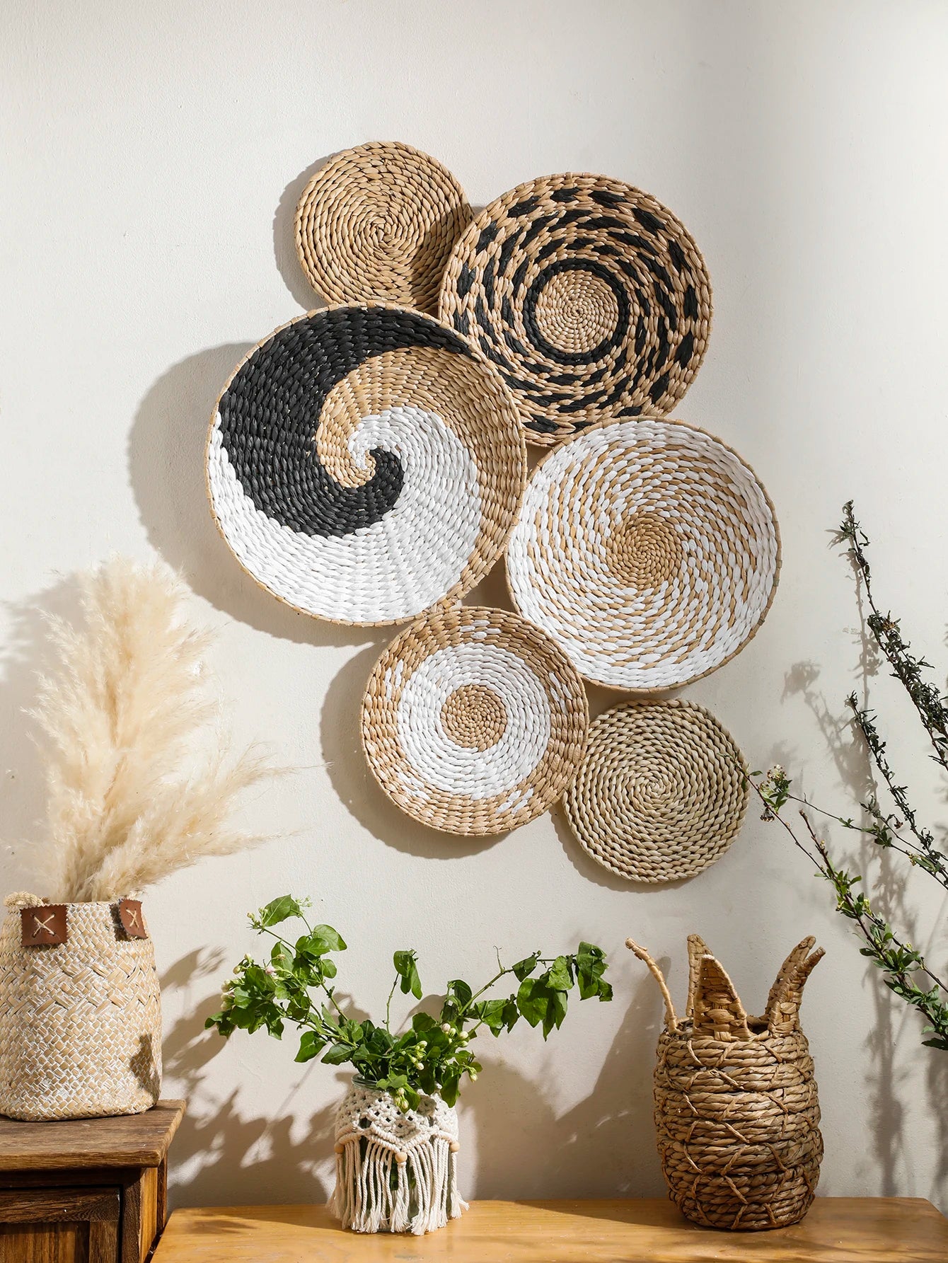 Panier mural en jonc de mer naturel tressé à la main, accroché sur un mur blanc dans un salon à la déco bohème. Décoration intérieure