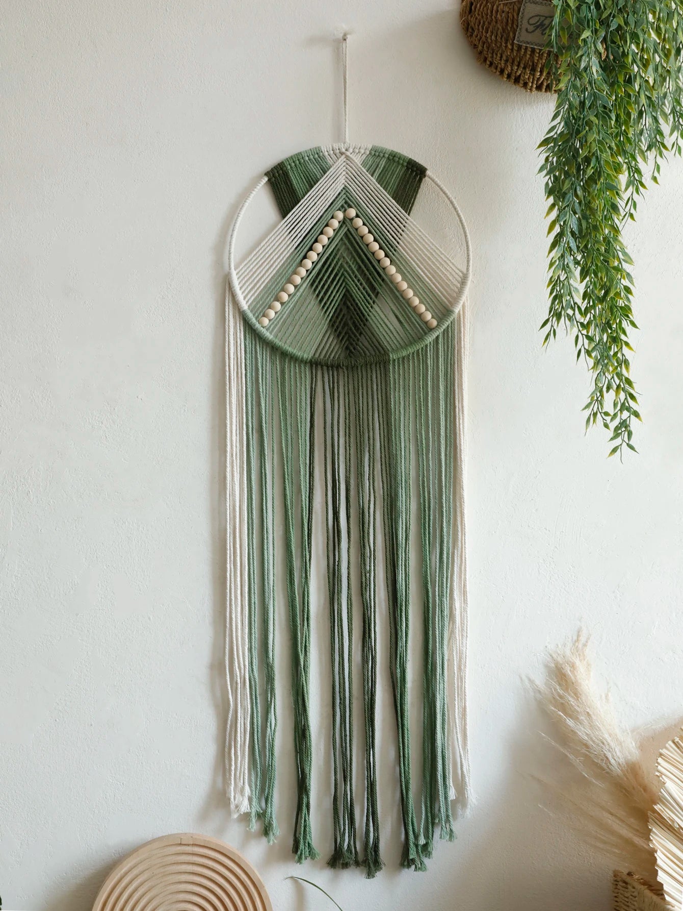 Tapisserie murale bohème en macramé avec franges et perles bois suspendue dans un salon cosy avec déco naturelle - Décoration intérieure