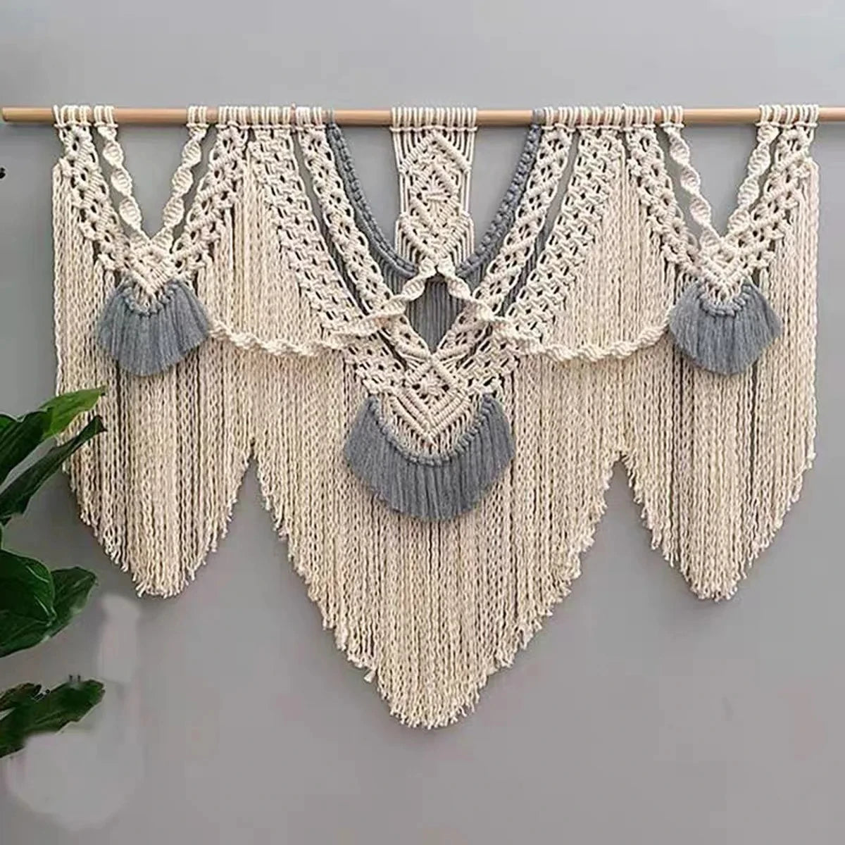 Tapisserie murale en macramé coloré suspendue avec trois bâtons en bois, décor bohème dans une chambre lumineuse - Décoration intérieure