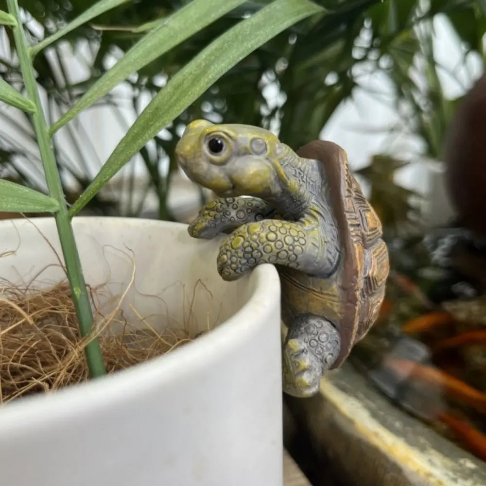 Tortue décorative en résine à accrocher sur un pot ou une rambarde).
